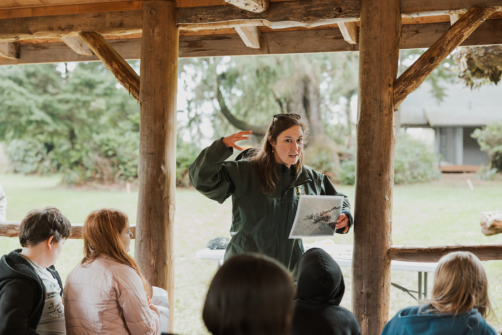 volunteer in fish and wildlife uniform teaches group of students