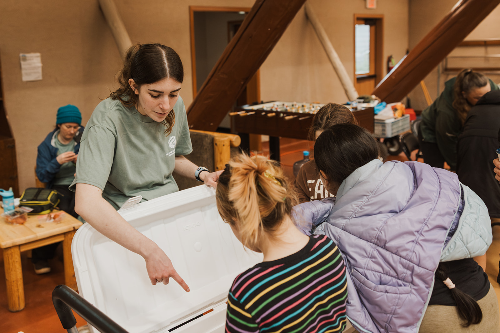 volunteer poitns something out to the students in the marine touch tank