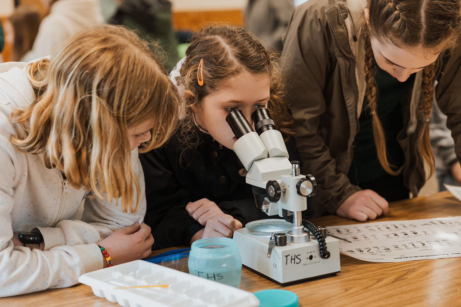 two students looking through a microscope